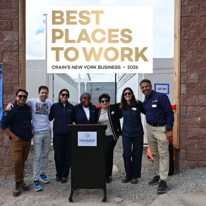 NineDot Team Members posing for photo with CRAINS 2023 best places to work in NYC banner